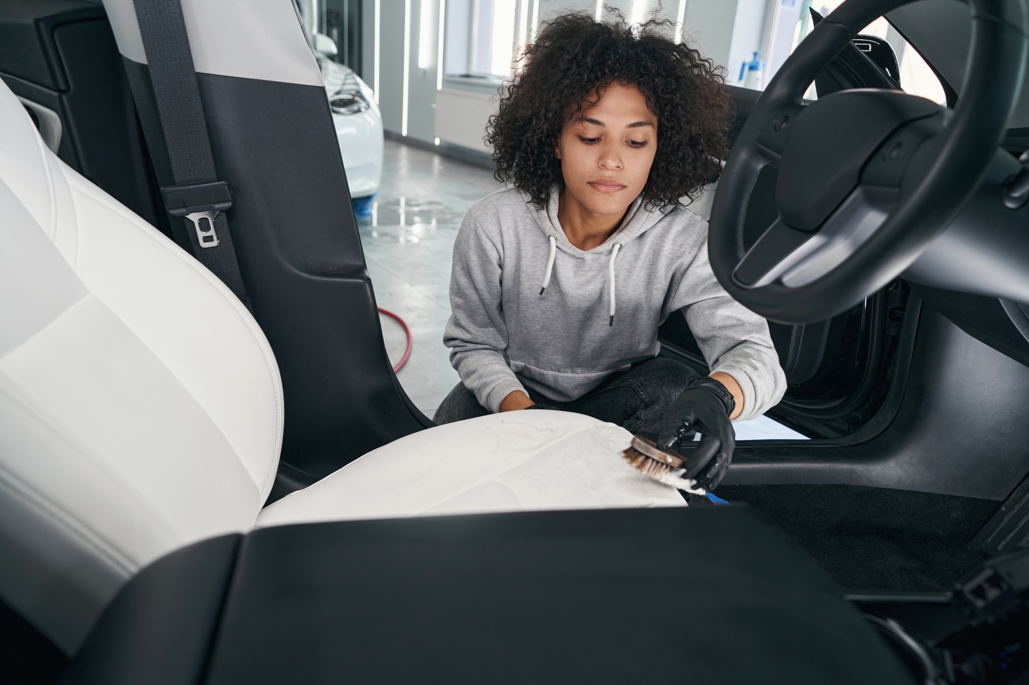 Concentrated service station worker brushing automotive upholstery